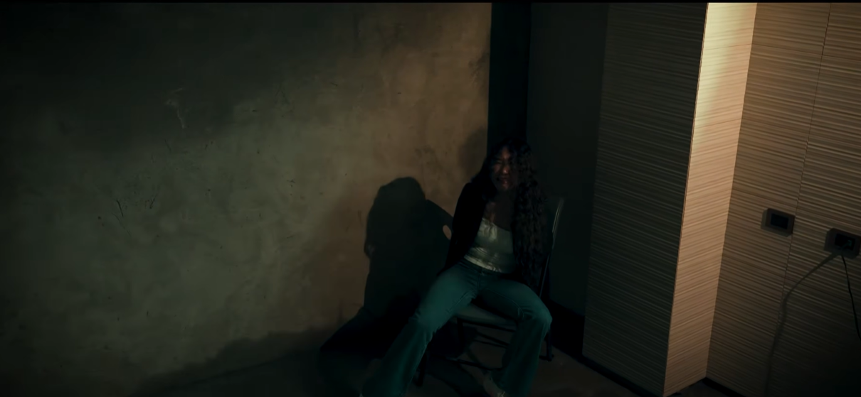 A captive woman sits alone in Echoes of Death
